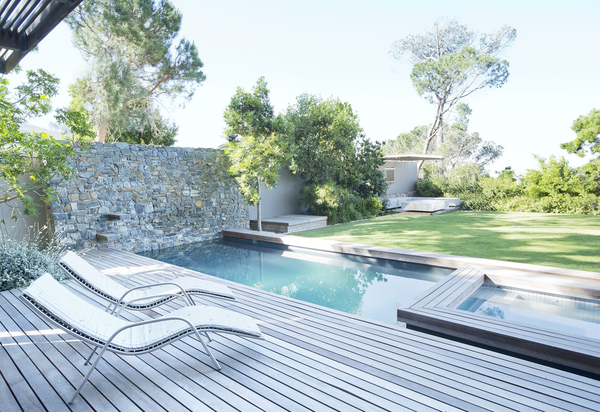 Lawn chairs and swimming pool in backyard